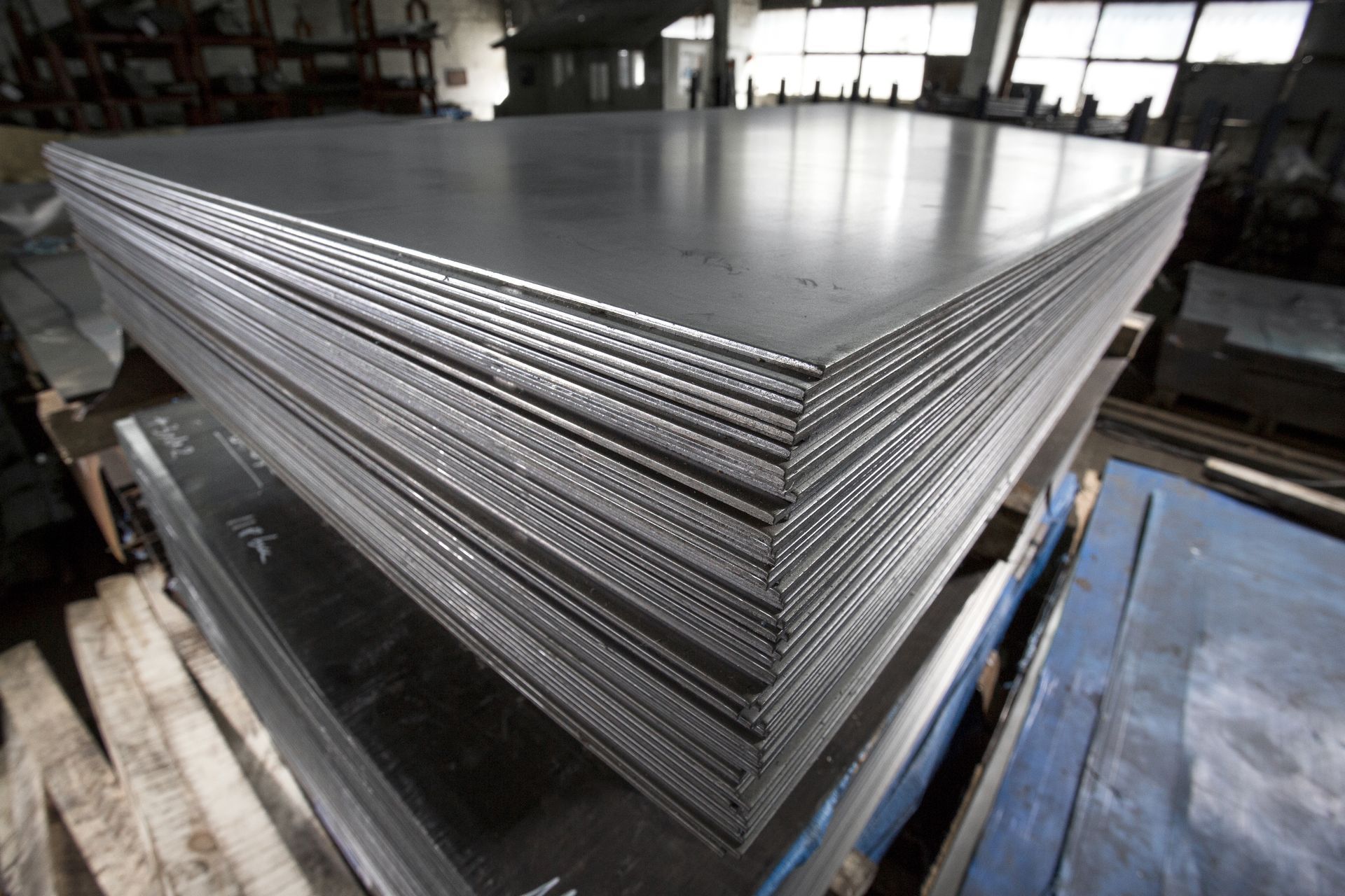A stack of metal sheets are stacked on top of each other in a factory.