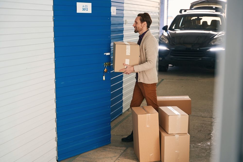A Man is Carrying a Box Into a Storage Unit — Dunford Removals in Biggenden, QLD