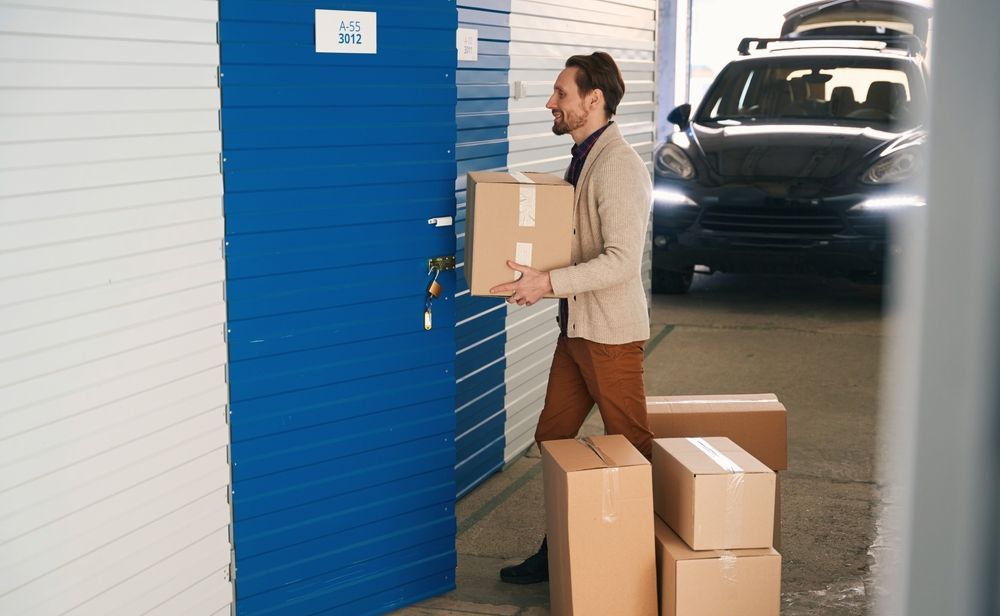 A Man is Carrying a Box Into a Storage Unit — Dunford Removals in Bargara, QLD