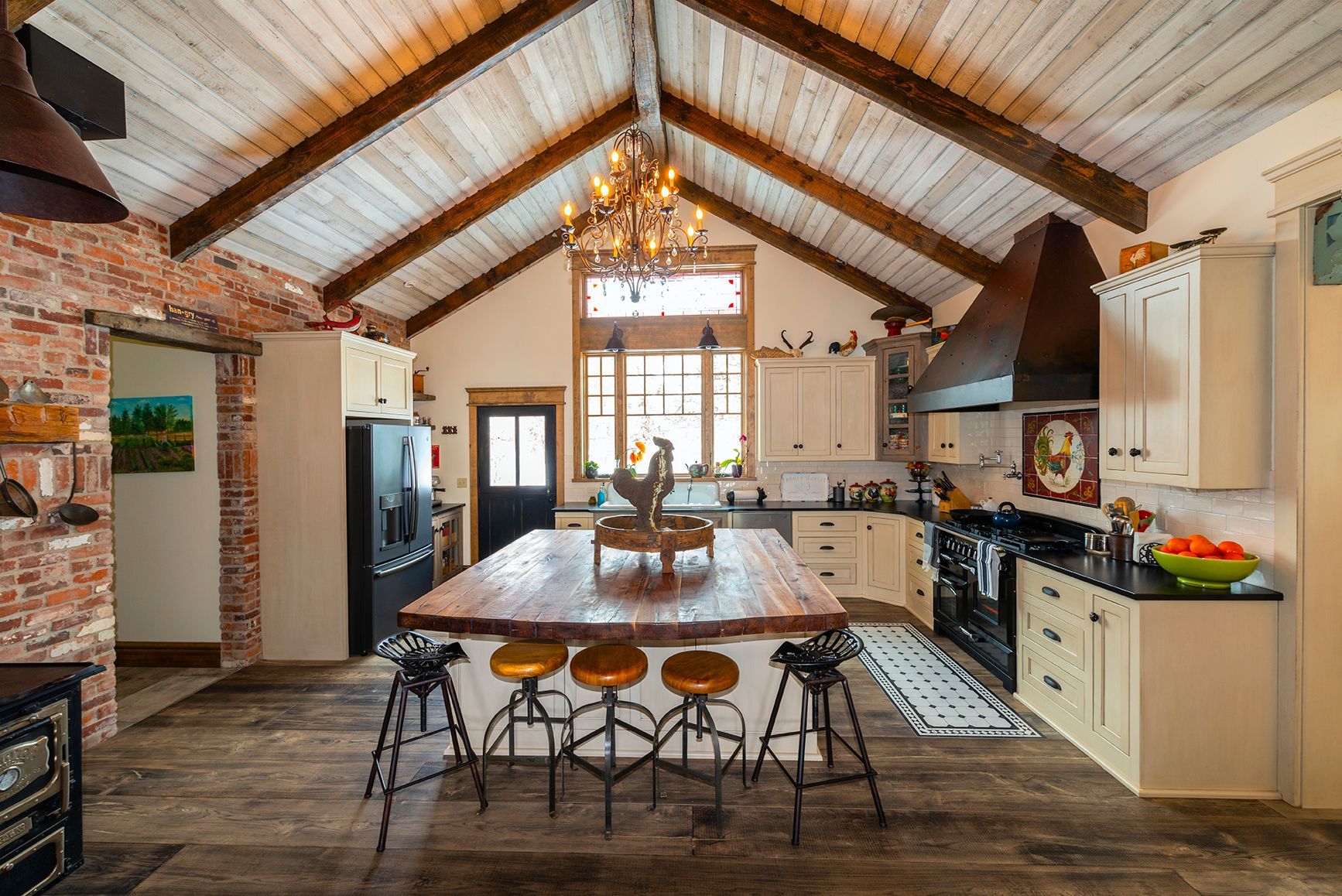 A kitchen with a large island in the middle and a chandelier hanging from the ceiling.
