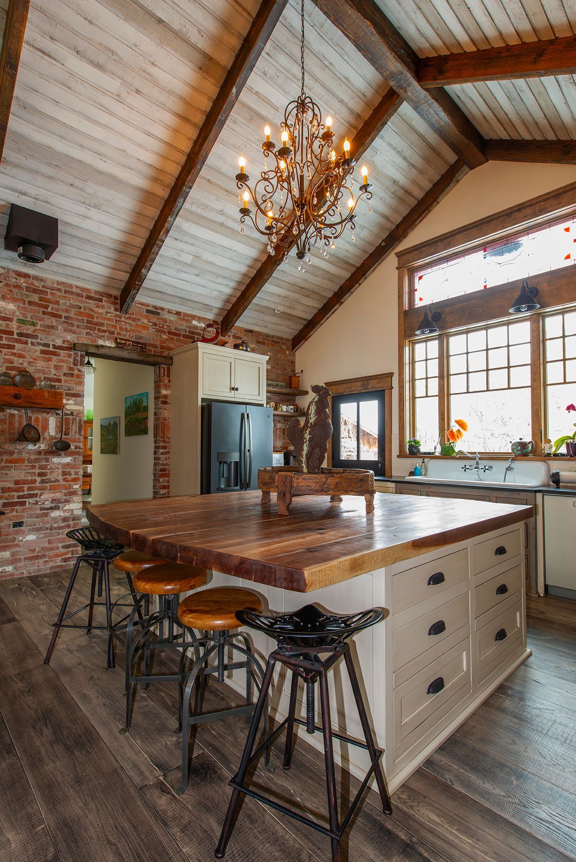 A kitchen with a large island and a chandelier hanging from the ceiling.