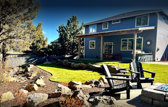 A house with a fire pit and chairs in front of it