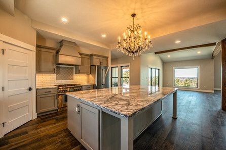 A kitchen with a large island and a chandelier hanging from the ceiling