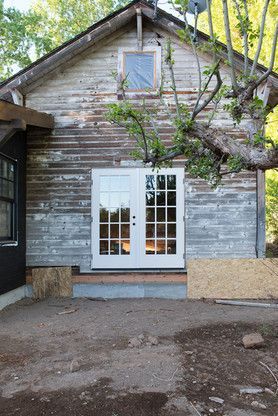 A house with a white door and a tree in front of it