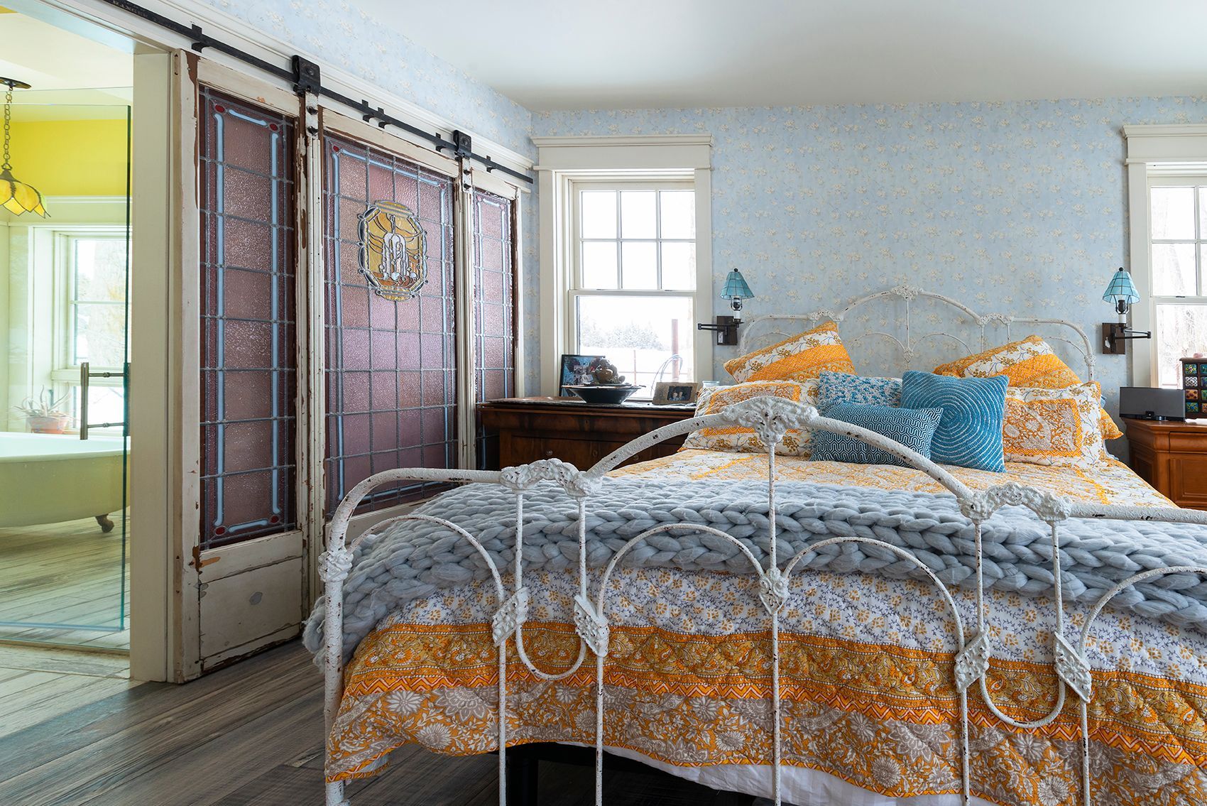 A bedroom with a bed and a sliding barn door.