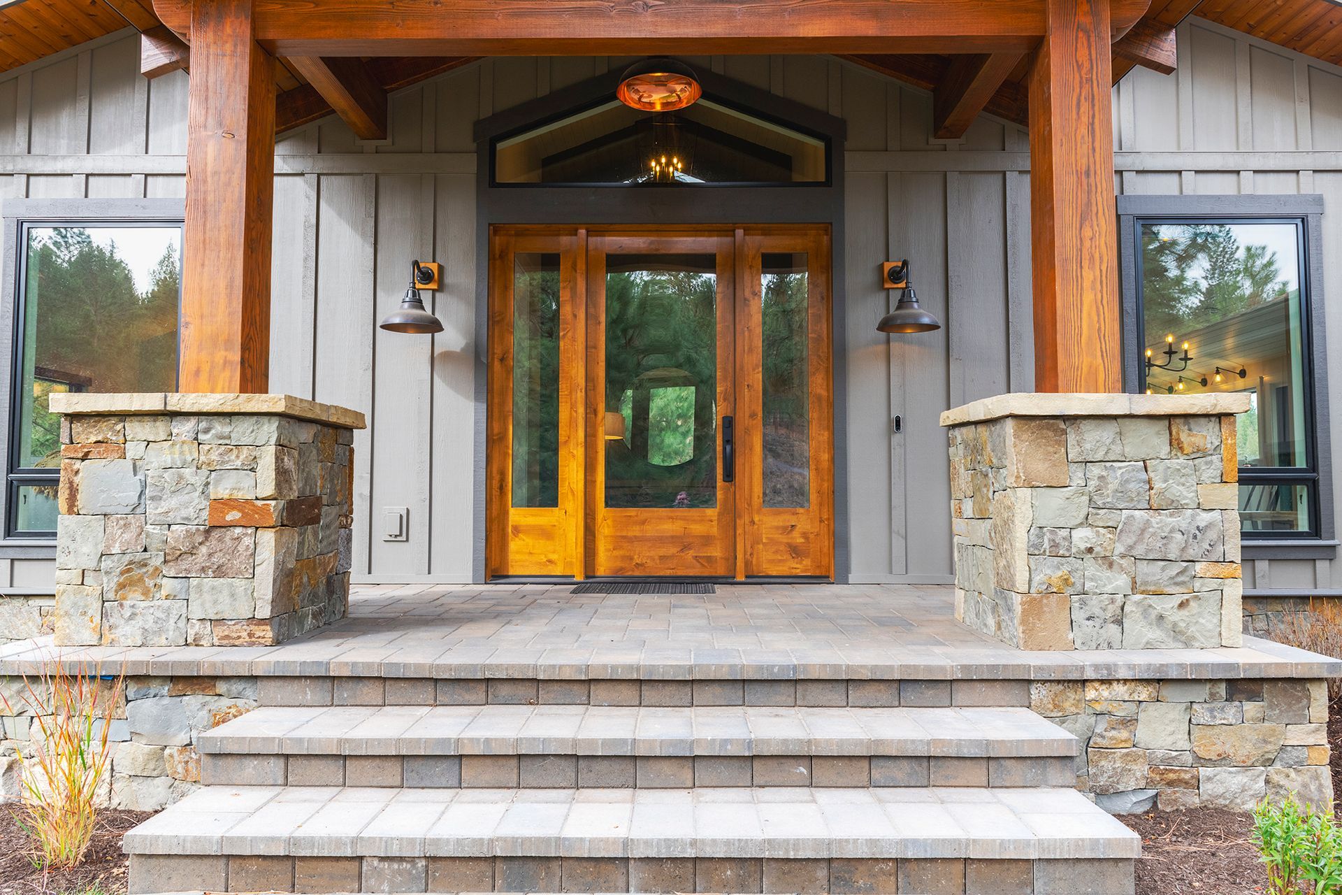 A large house with a porch and stairs leading to the front door.