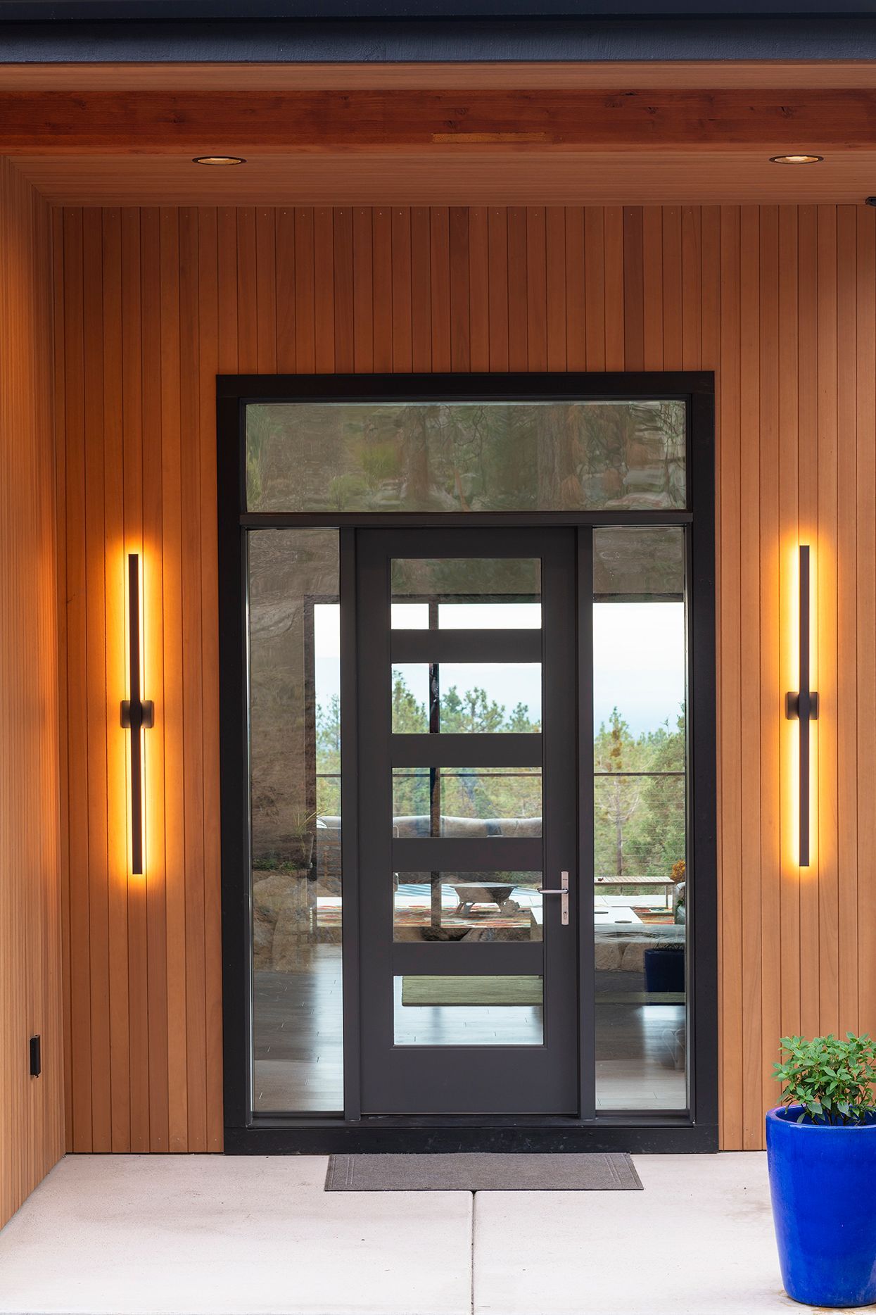 The front door of a house with a blue pot in front of it.