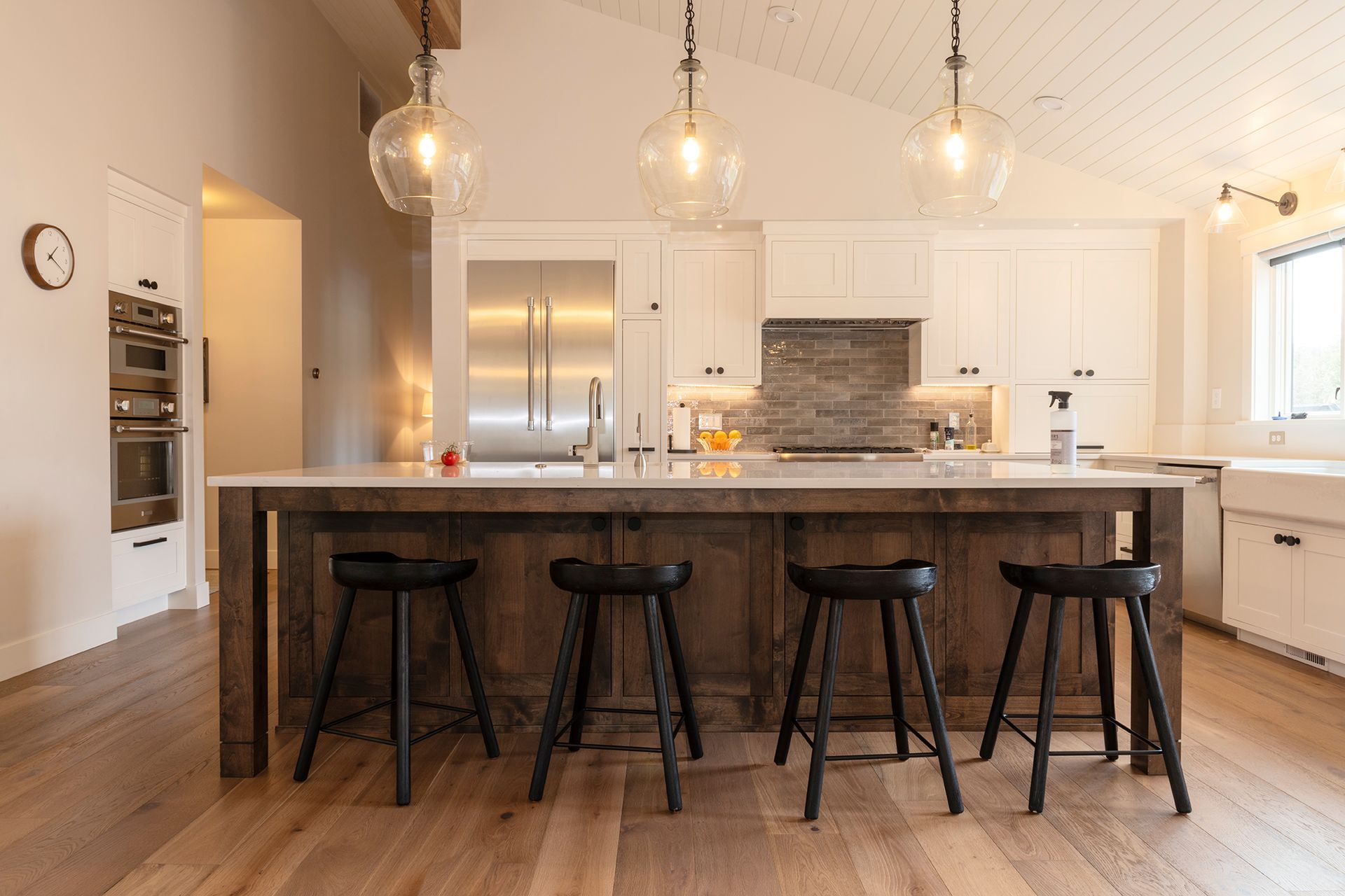 A kitchen with a large island and four stools.