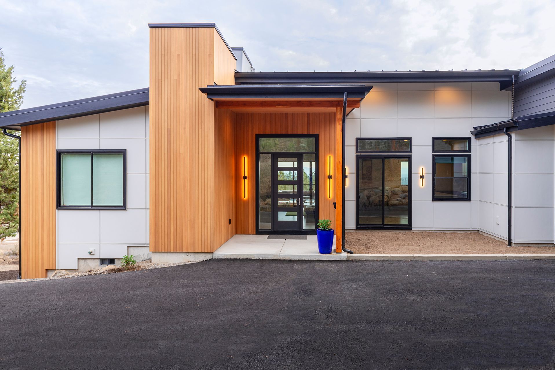 A white house with a wooden porch and a black door