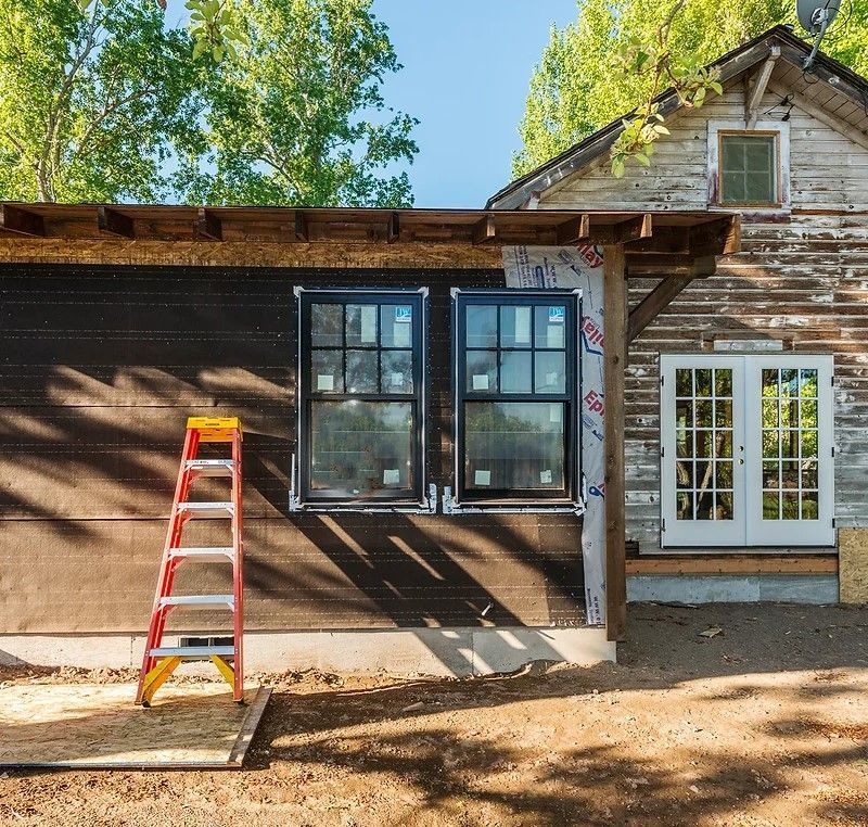 A house is being remodeled with a ladder in front of it
