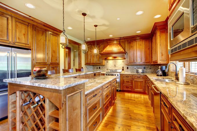 A large kitchen with wooden cabinets and granite counter tops