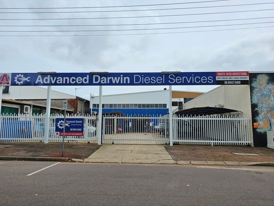 A Man Is Working On A Car In A Garage — Advanced Darwin Diesel Service In Darwin City, NT