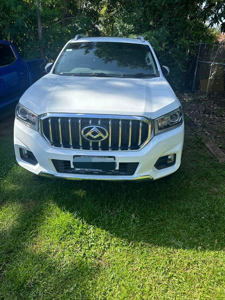 A White Car With A Chrome Grille Is Parked In The Grass — Advanced Darwin Diesel Service In Darwin City, NT
