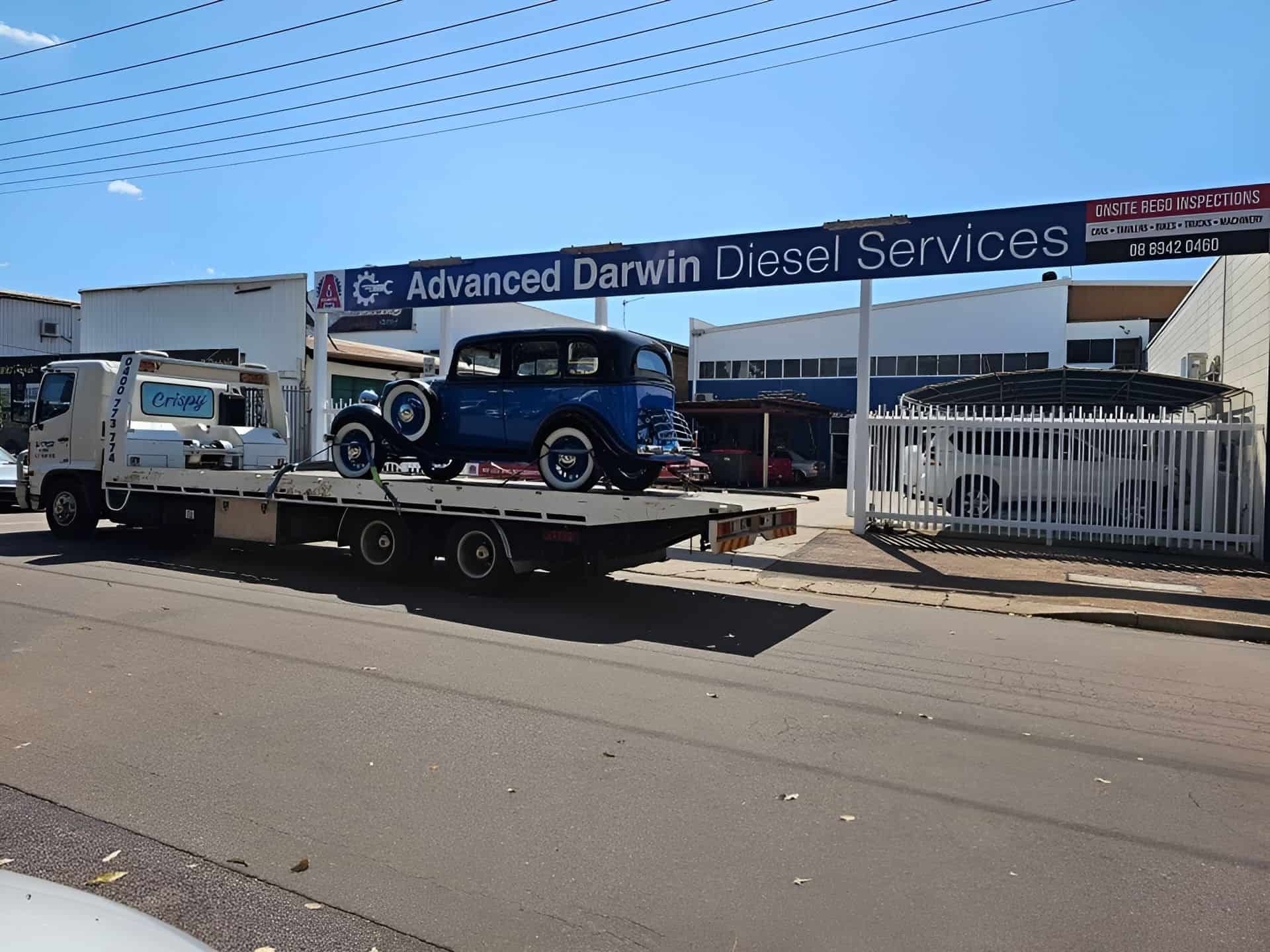 A Blue Car Is On A Flatbed Truck In Front Of Advanced Darwin Diesel — Advanced Darwin Diesel Service In Darwin City, NT