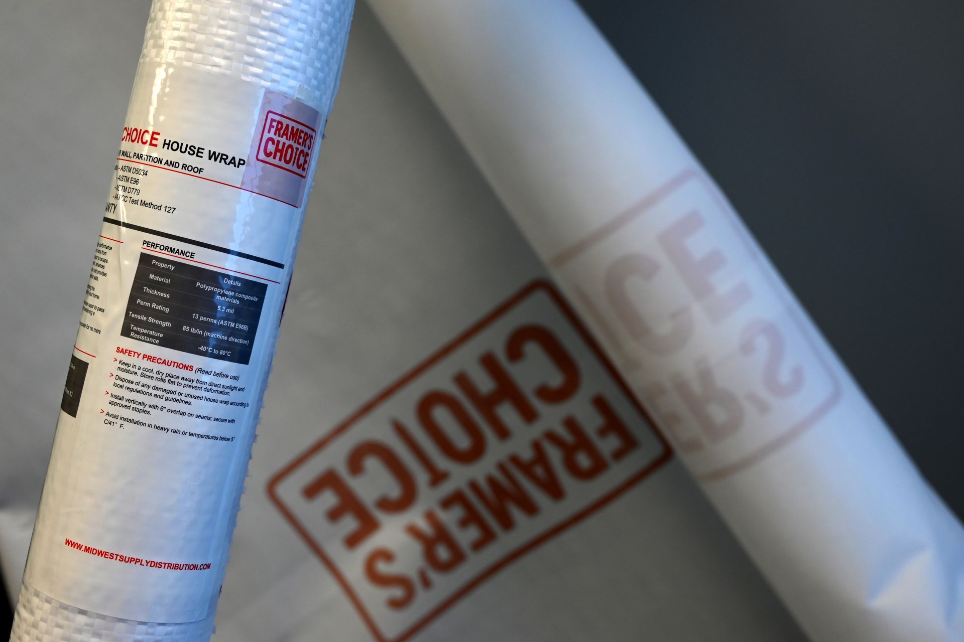 Close-up of a wrapped Framer's Choice house wrap roll with product label visible.