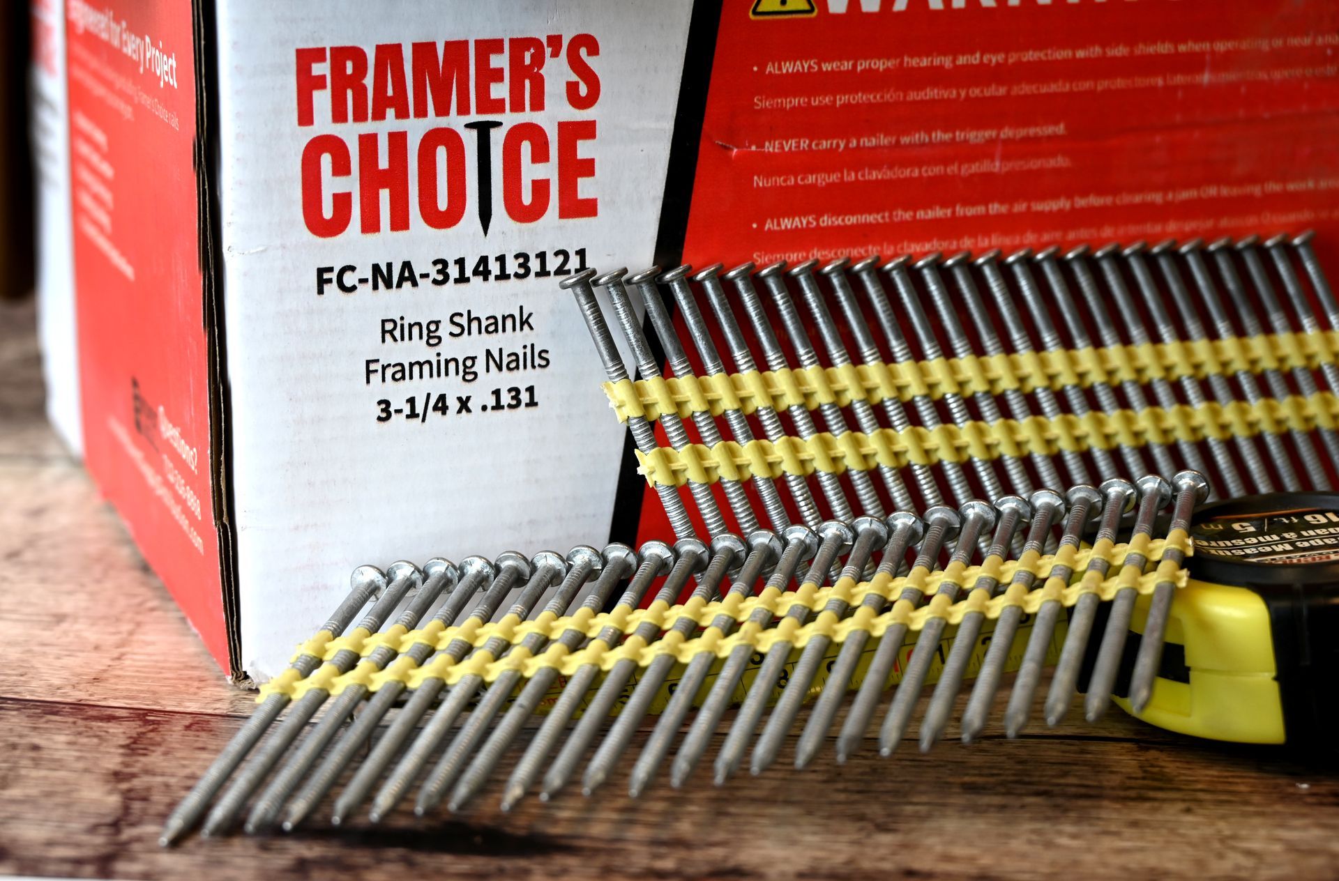 A bundle of metal nails with yellow bands, arranged diagonally on a light surface.