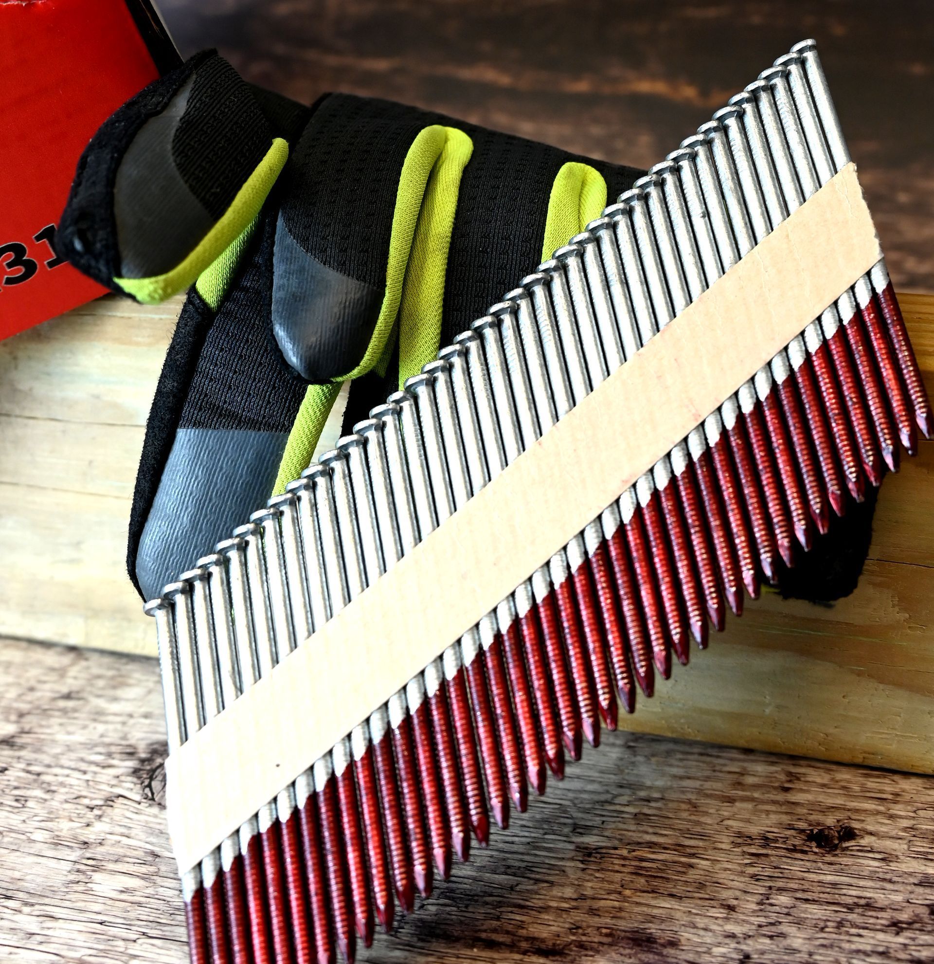 Close-up of a red, white, and gray striped woven ribbon on a rustic wood surface.