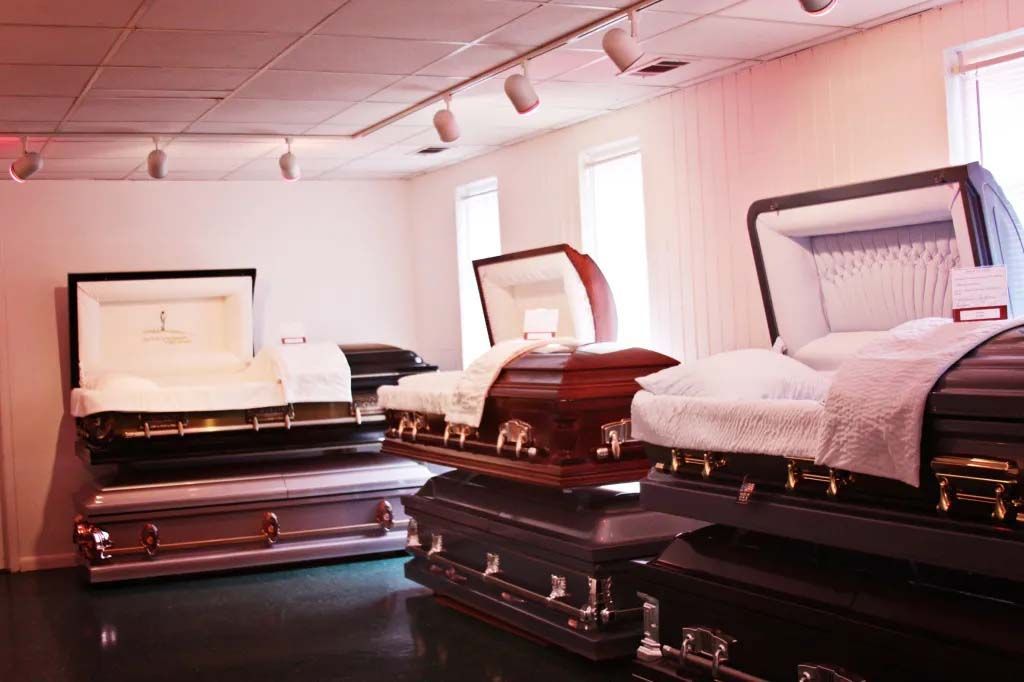 A room filled with lots of coffins in a funeral home.