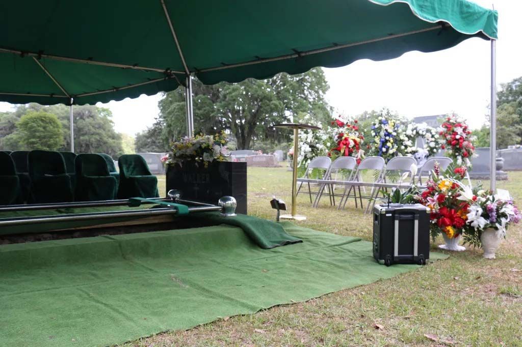 A green tent is sitting in the middle of a grassy field.