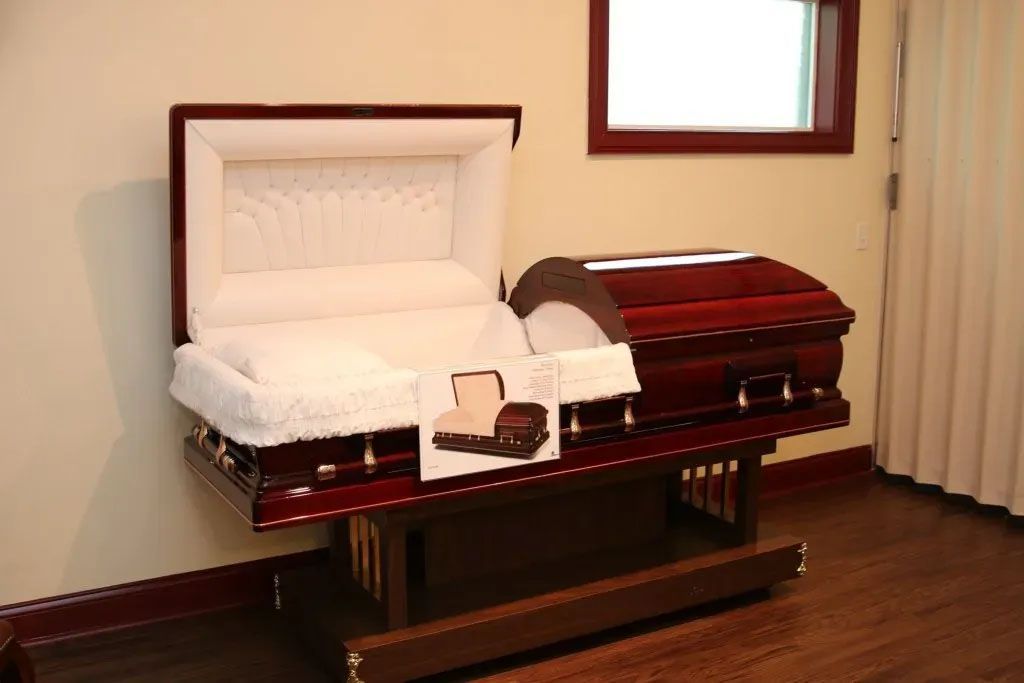 An open coffin is sitting on a wooden table in a room.