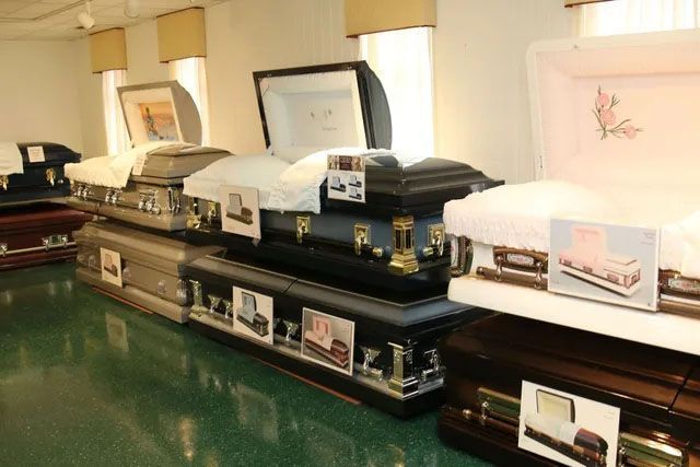 A row of coffins are lined up in a room.