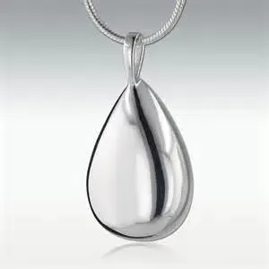 A close up of a silver pendant on a chain on a white surface.