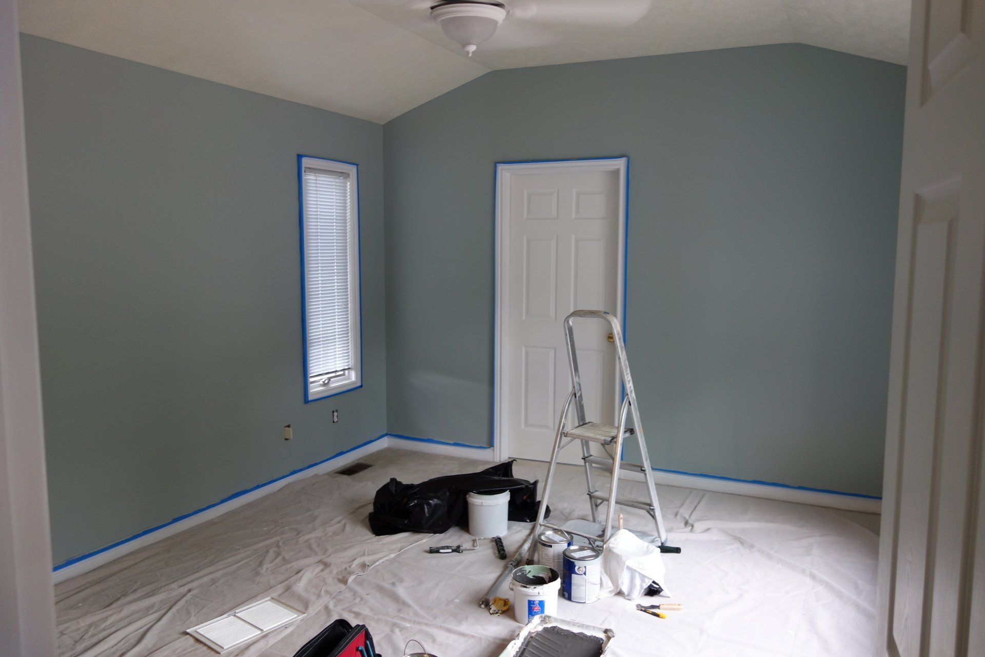 An interior view of a bedroom with freshly painted walls in a soothing shade of blue.