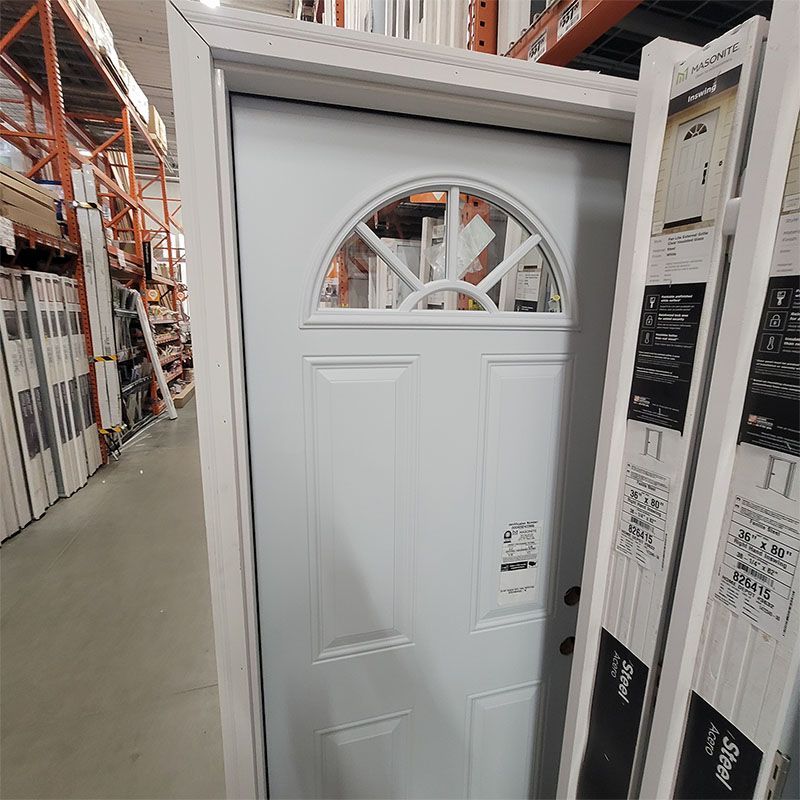 White front door with arched window panel at a home improvement store.
