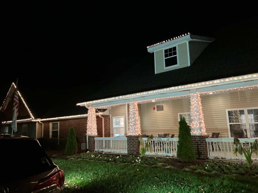 House decorated with white Christmas lights at night.