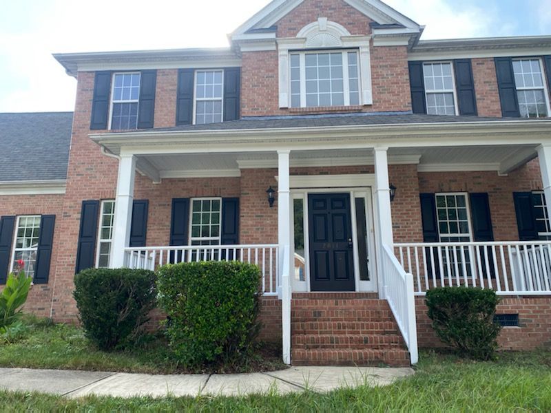 Brick house with white porch and black door