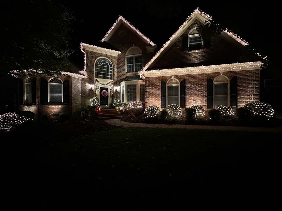 Lit-up house at night, decorated with Christmas lights on the roof