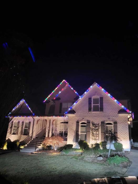 House at night decorated with colorful Christmas lights.