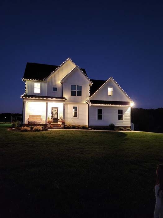 White house at night with glowing lights and a dark sky.
