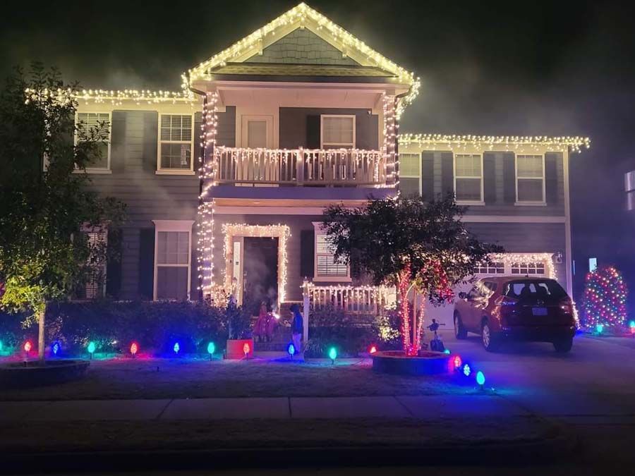 House decorated with colorful Christmas lights at night.