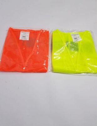 Dos camisetas de neón dobladas, en su embalaje de plástico, una naranja y otra amarilla, sobre una superficie blanca.