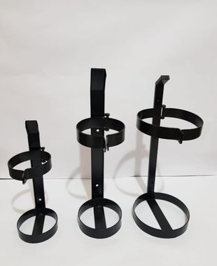 Tres soportes de metal negro con forma de anillo, de diferentes alturas, sobre un fondo blanco.