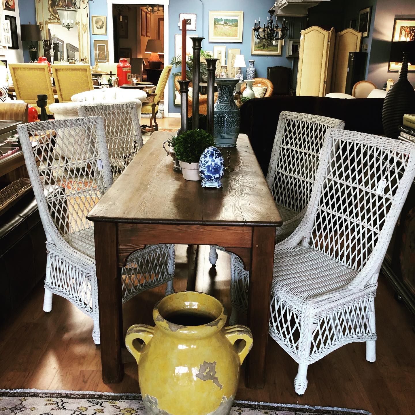 A table with wicker chairs and a yellow vase