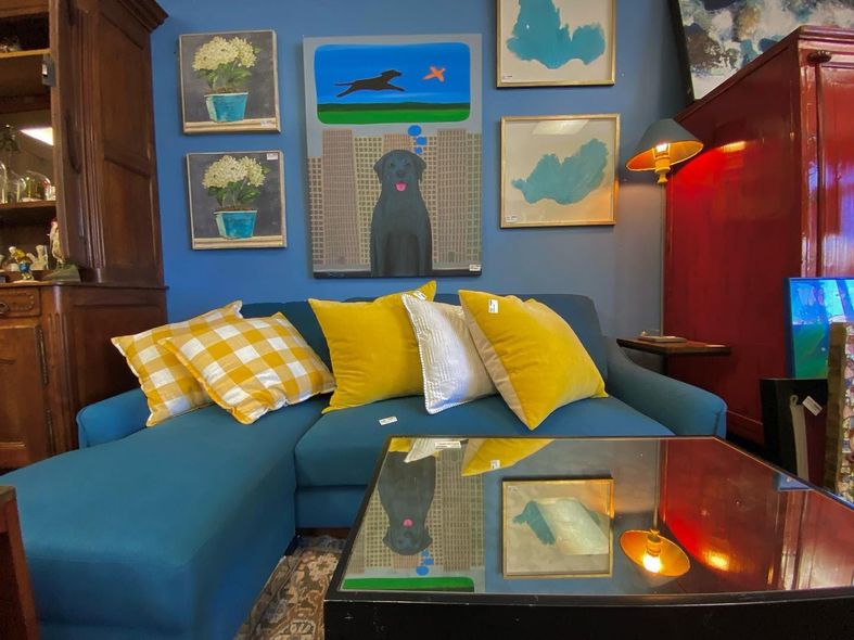 A living room with a blue couch and yellow pillows