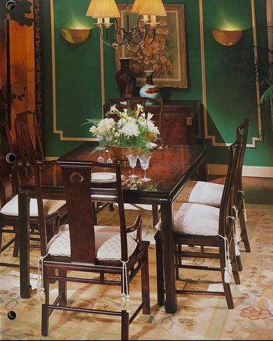 A dining room table with a vase of flowers on it