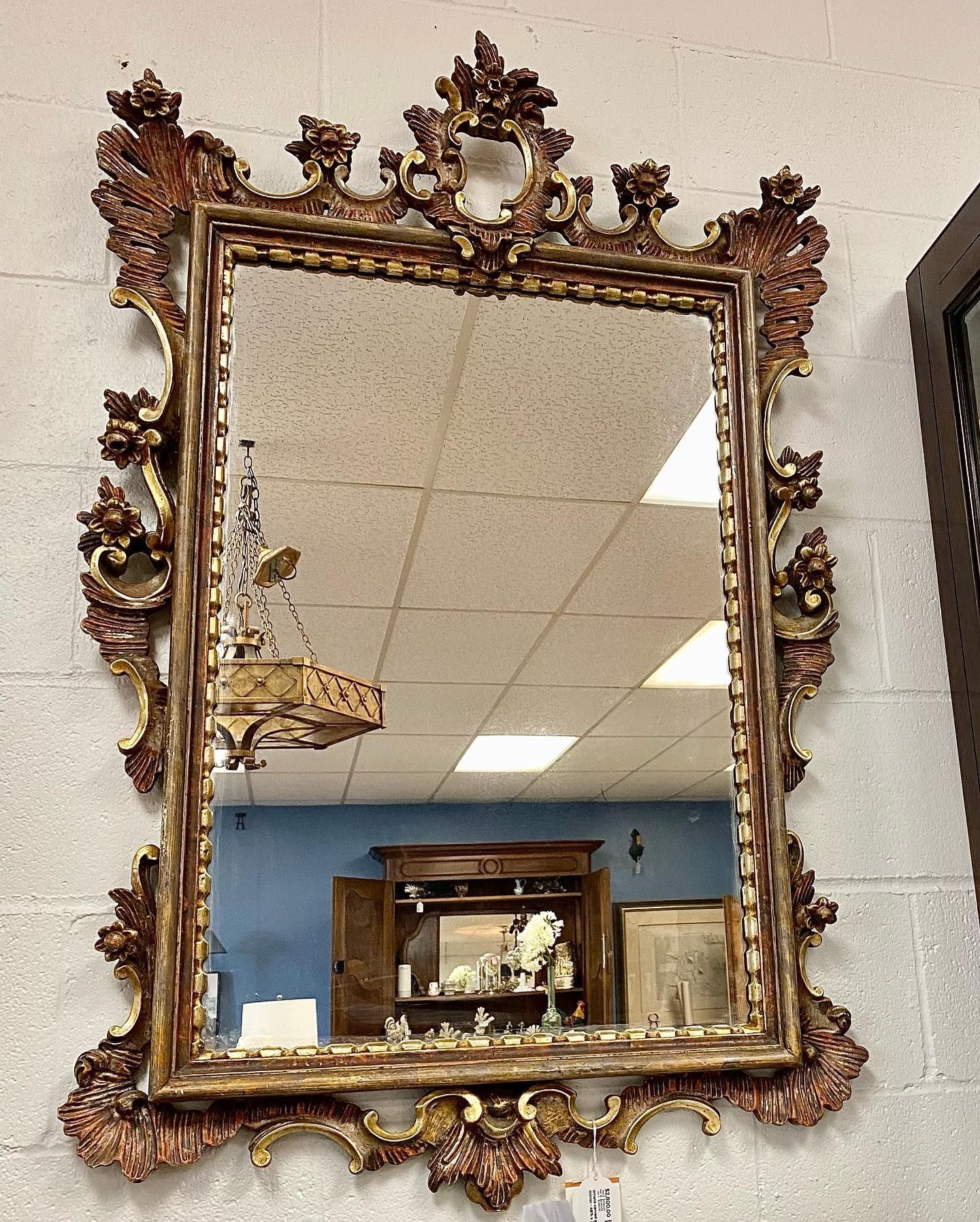 A large mirror is hanging on a brick wall