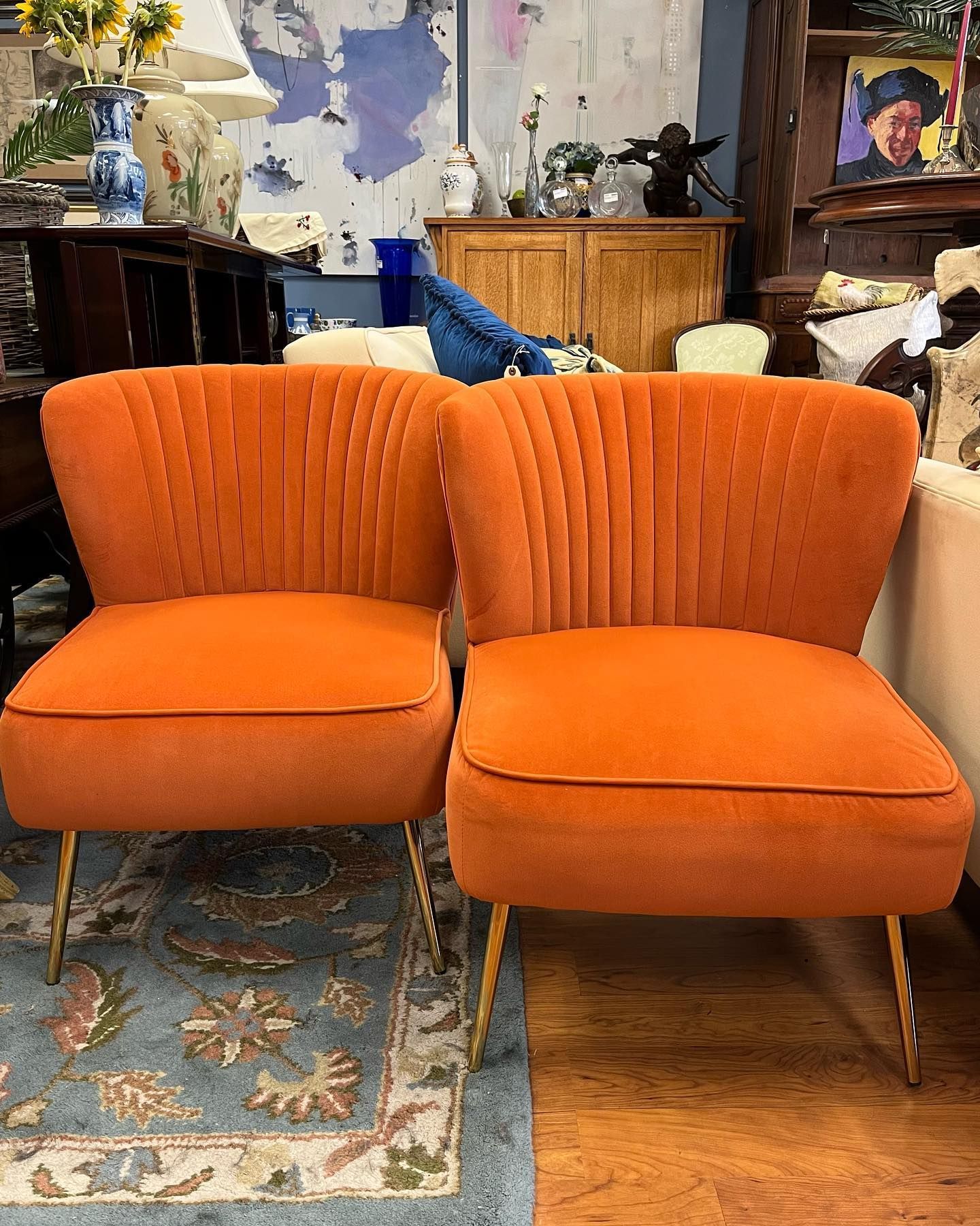 Two orange chairs are sitting next to each other in a living room.