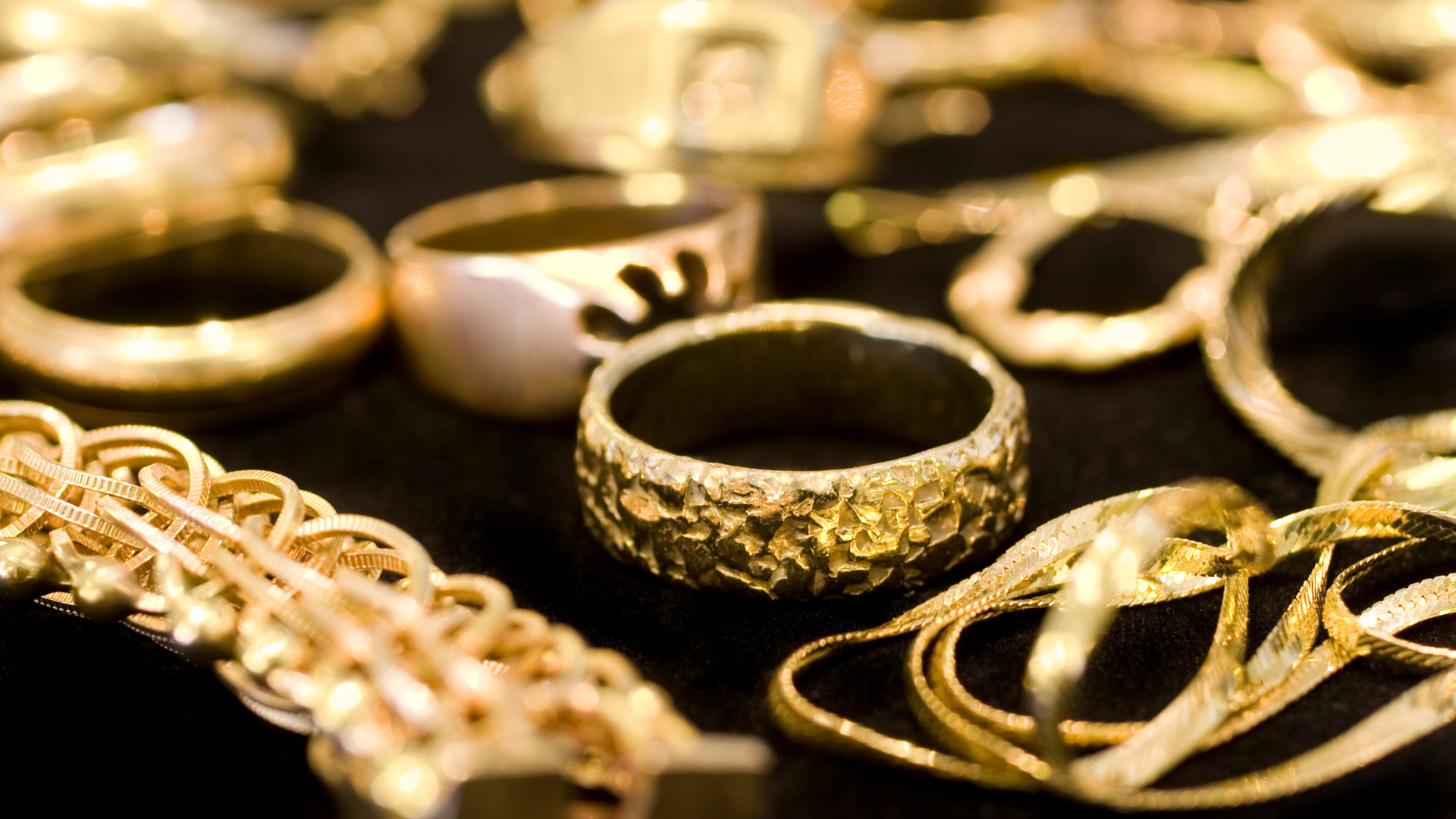 There are many different types of gold jewelry on the table.
