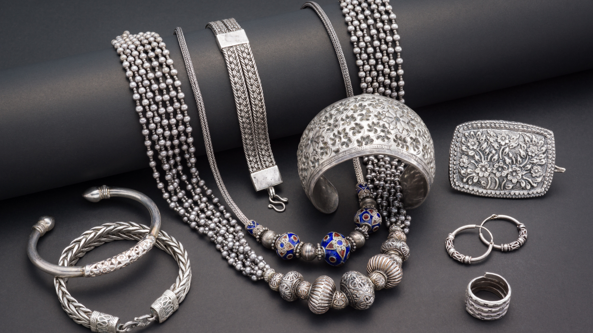 A collection of silver jewelry including bracelets necklaces and rings