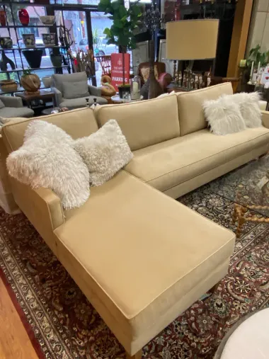 A large sectional couch is sitting on top of a rug in a living room.
