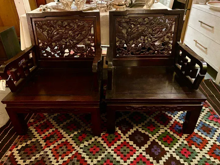 Two wooden chairs are sitting next to each other on a rug.