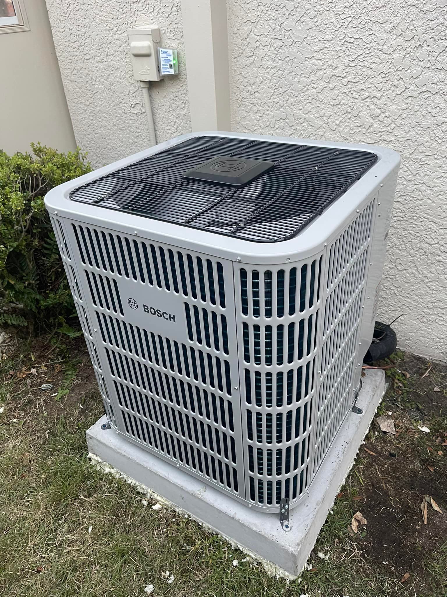 A large air conditioner is sitting outside of a building.