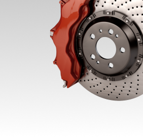 Red brake caliper clamping a drilled brake rotor | Libertyville Kar Care