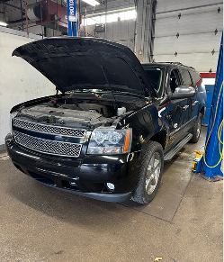 Black SUV with hood open in a repair shop | Libertyville Kar Care