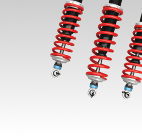Three red and black motorcycle shock absorbers against a white background | Libertyville Kar Care