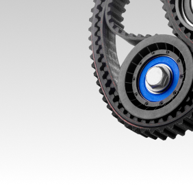 Black toothed belt wrapped around pulleys with blue and silver accents | Libertyville Kar Care